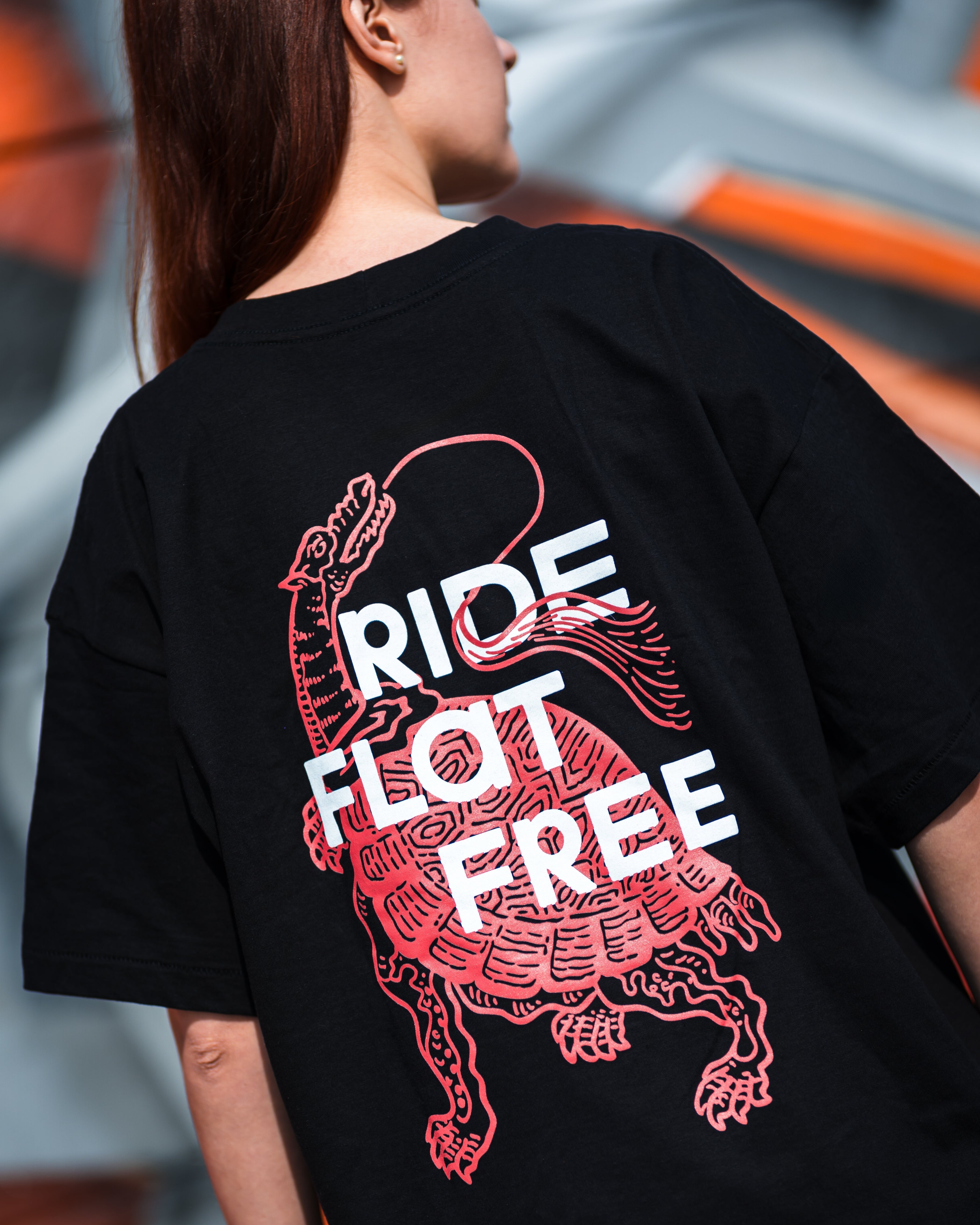 Person wearing a black t-shirt with a graphic design and text on the back.